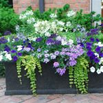 A brown decorative container with white and purple flowers