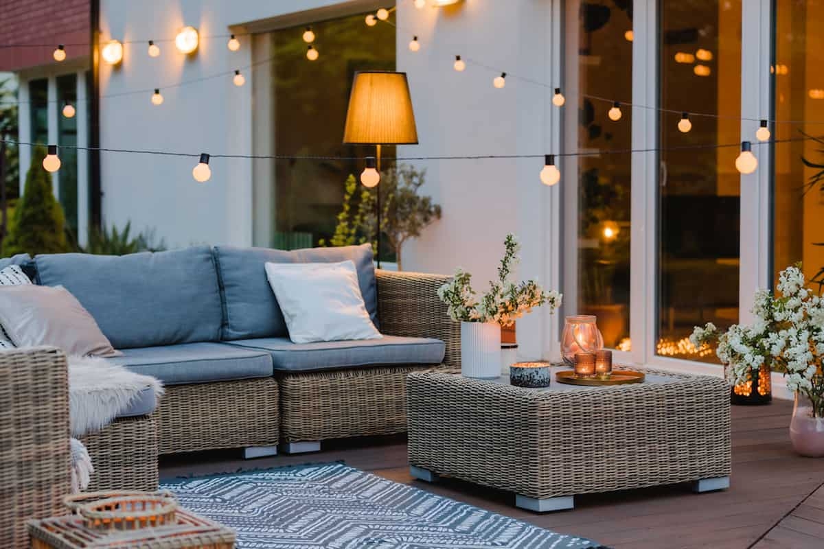 Wicker sofa and chair with cushions and end table in an outdoor furniture setting