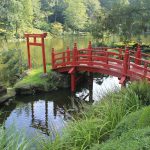 A classic red bridge in a classic Japanese garden