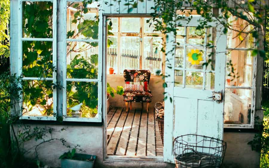 A garden room with many windows set up as a garden sitting area.