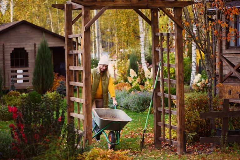 A woman pushing a wheelbarrow while doing gardening work