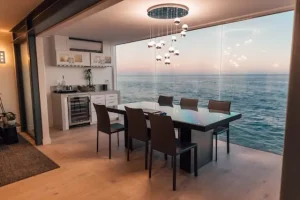Eat-in kitchen with Dining room table against outside window on the ocean