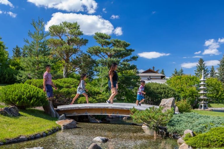 A family wiht tow children crossing a bridge over water at Nikka Yuko Japanese Garden